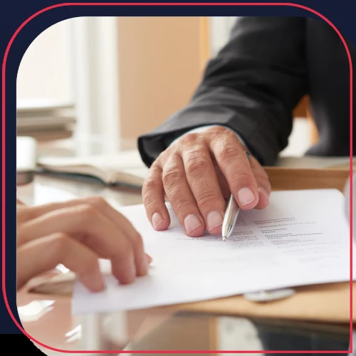 Mãos assinando documentos sobre uma mesa